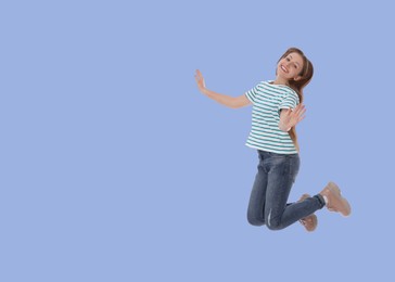 Image of Cute girl jumping on light blue background, space for text