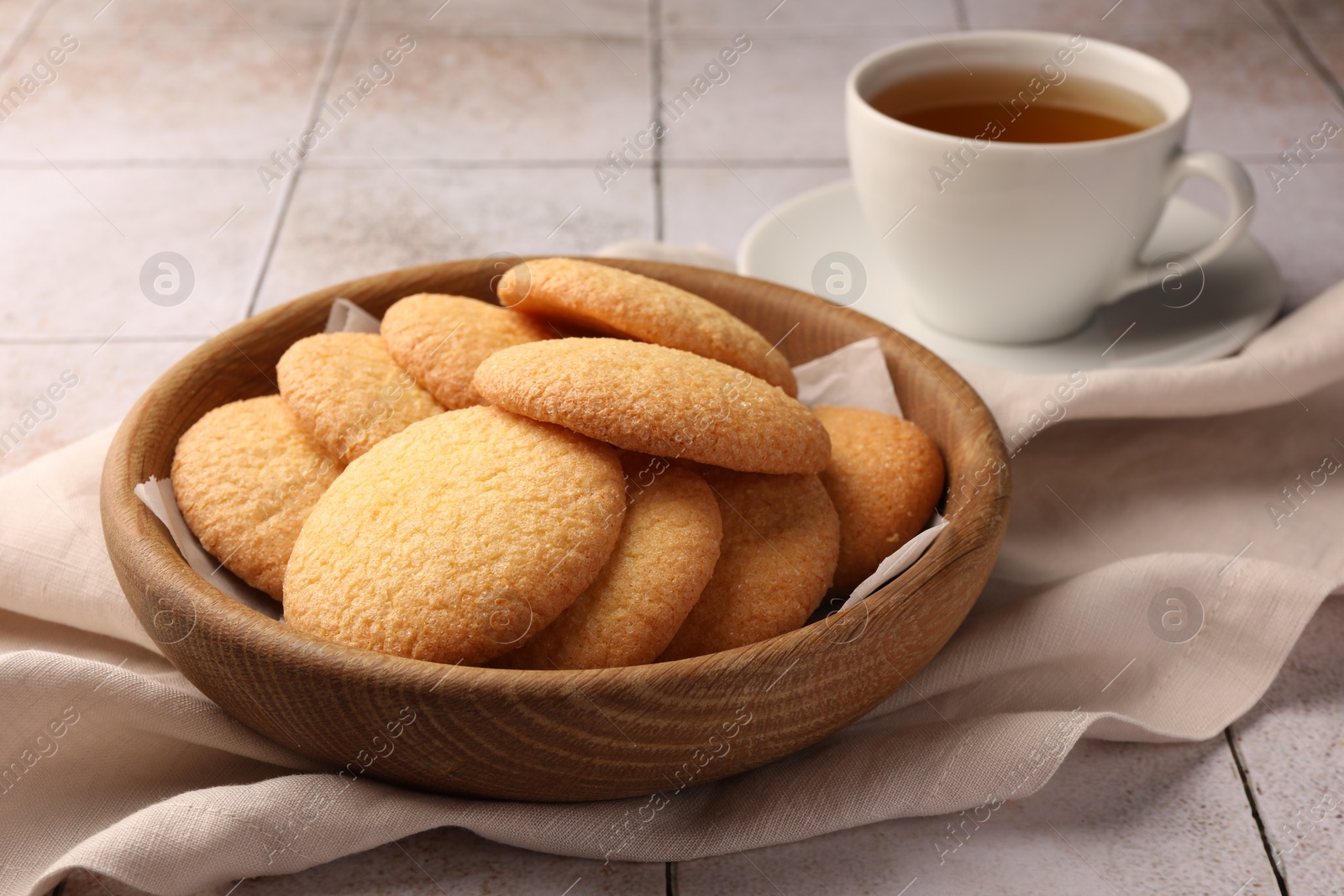 Photo of Delicious Danish butter cookies and tea on white tiled table, closeup