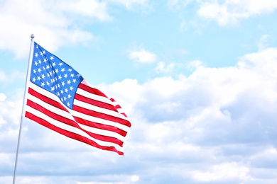 American flag outdoors on cloudy day. Space for text