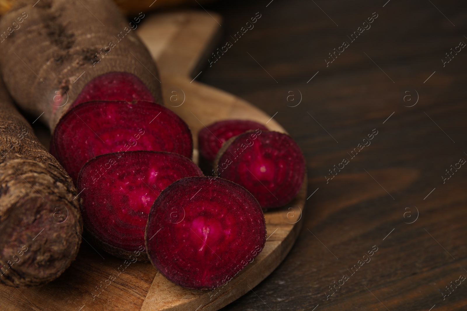 Photo of Whole and cut red beets on table, closeup. Space for text