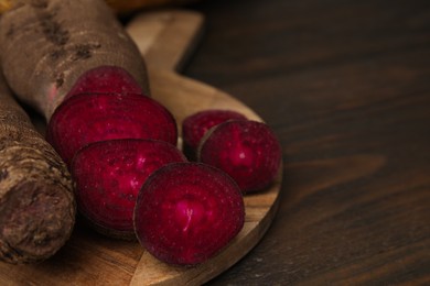 Photo of Whole and cut red beets on table, closeup. Space for text