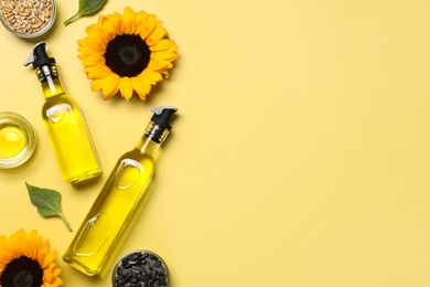 Flat lay composition with sunflower cooking oil on pale yellow background. Space for text