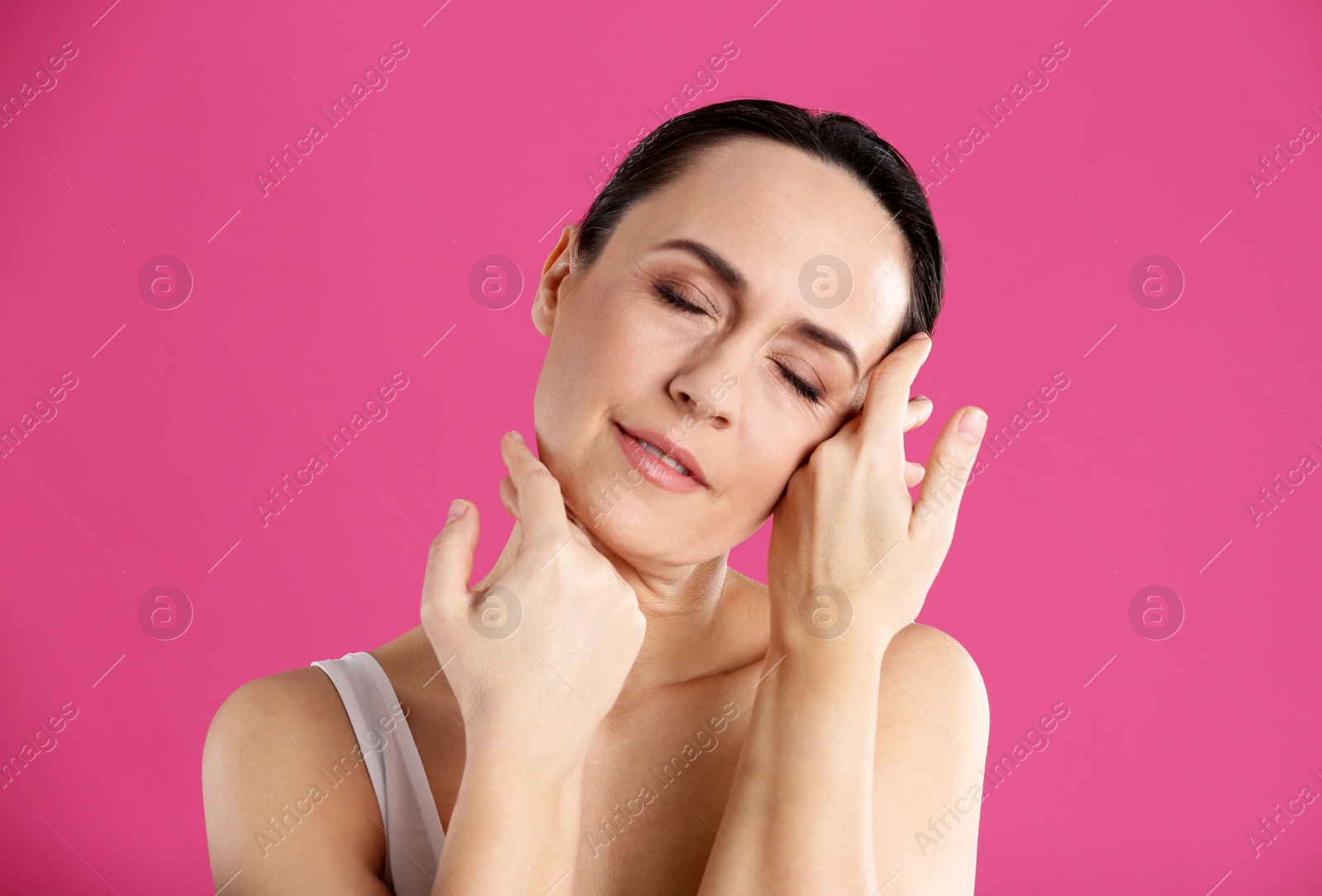 Photo of Portrait of beautiful mature woman on pink background