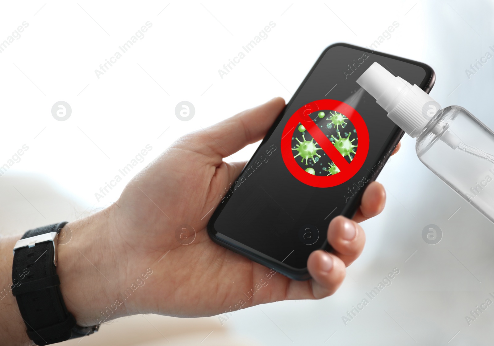 Image of Sanitizing mobile devices during coronavirus outbreak. Antiseptic spray and man with smartphone on light background, closeup