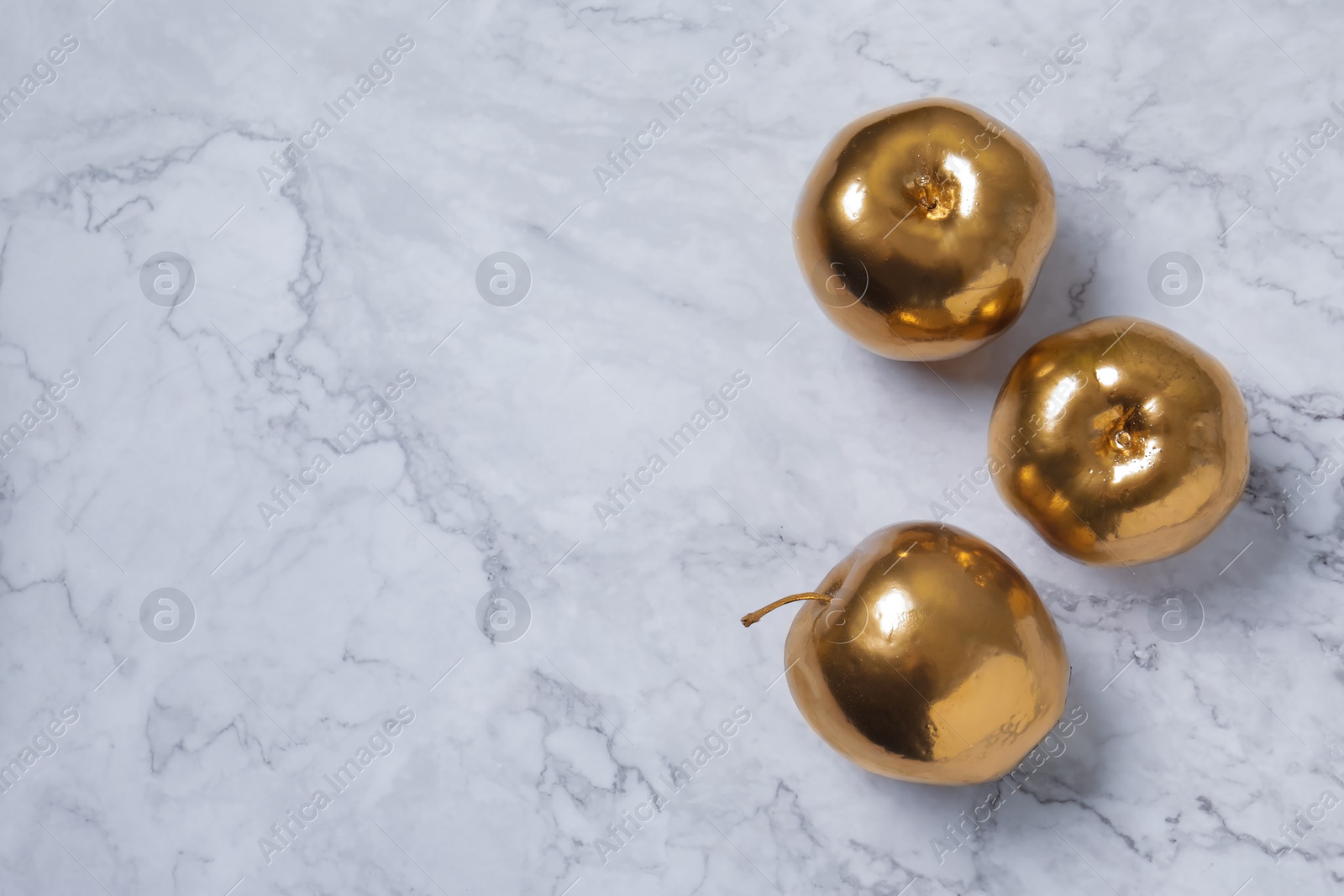 Photo of Golden apples on white marble table, flat lay. Space for text