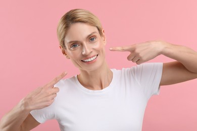 Photo of Woman showing her clean teeth and smiling on pink background