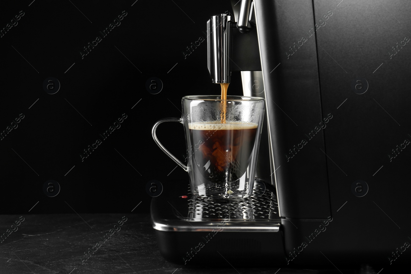 Photo of Making coffee with modern espresso machine on grey table against black background. Space for text