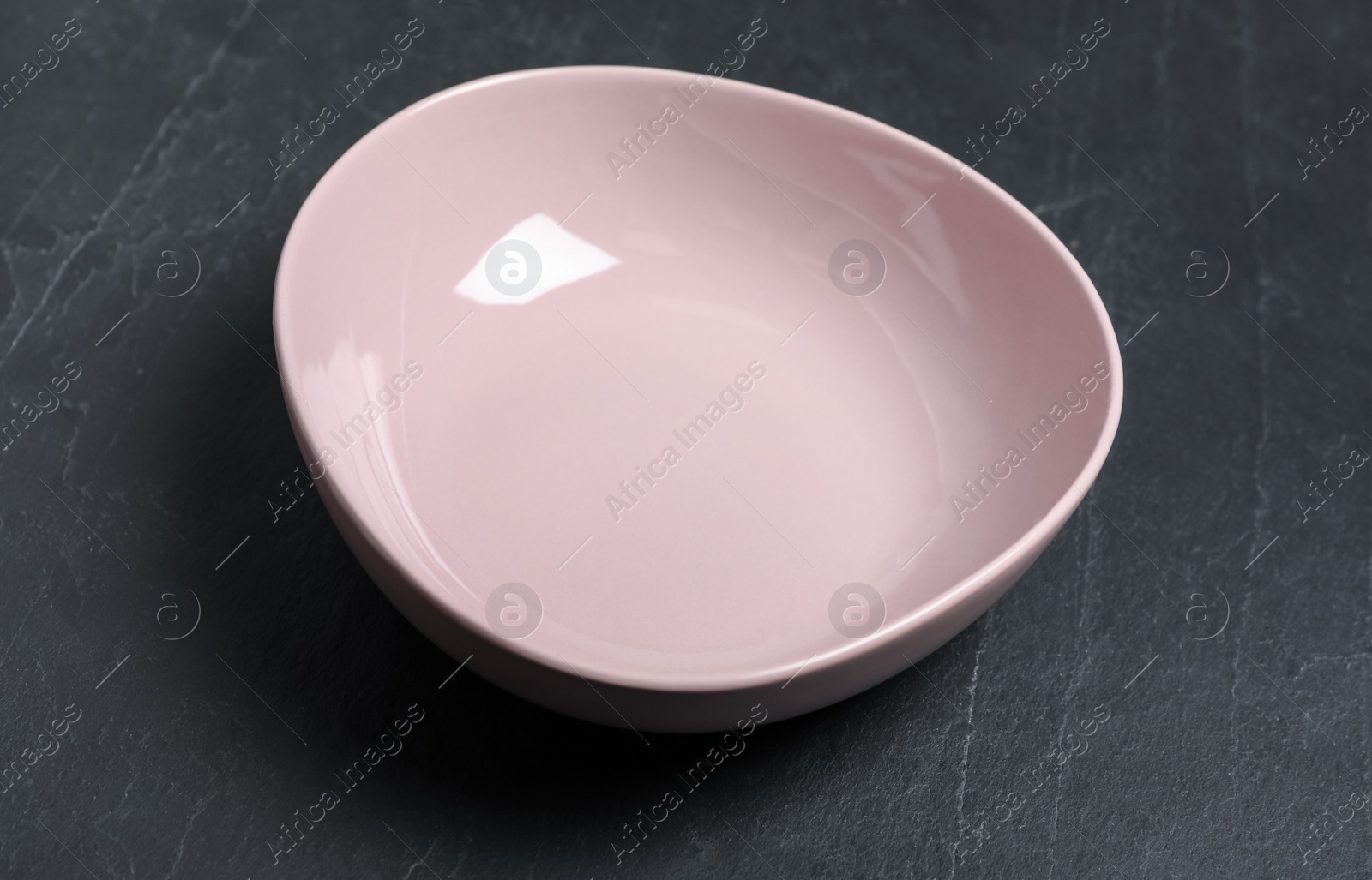 Photo of New clean bowl on black slate table