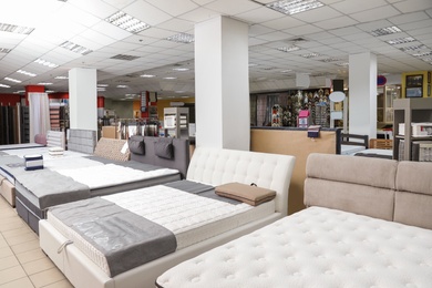 Photo of Different beds with orthopedic mattresses in store