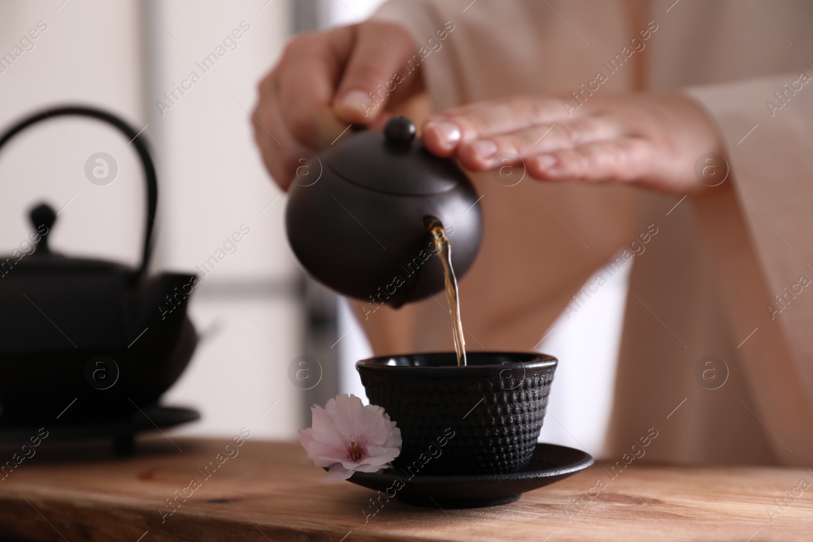 Photo of Master conducting traditional tea ceremony at table, closeup