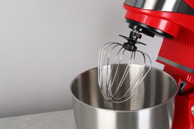 Photo of Modern red stand mixer on light gray background, space for text