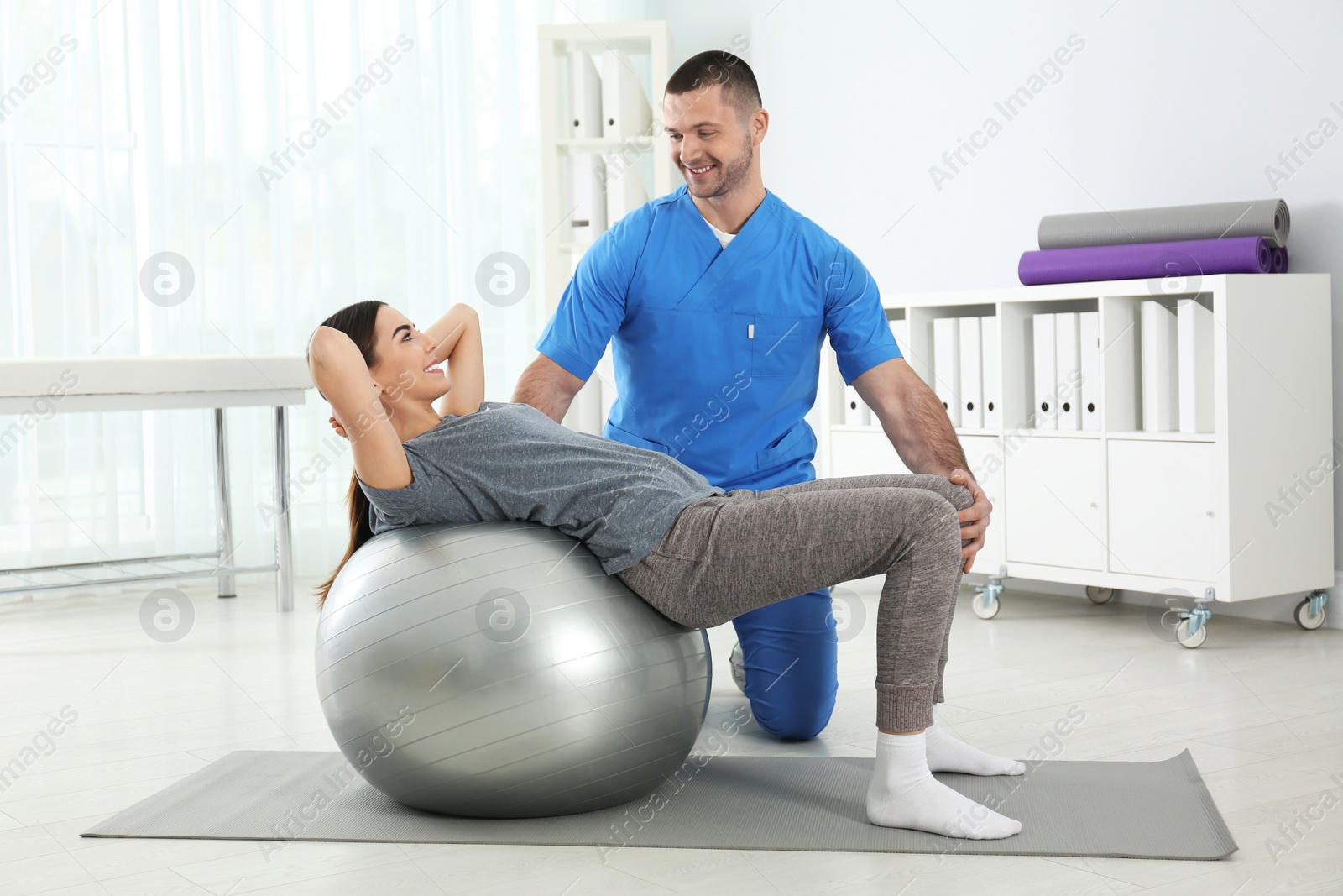 Photo of Doctor working with patient in hospital. Rehabilitation exercises