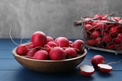 Photo of Bowl with fresh ripe radishes on blue wooden table