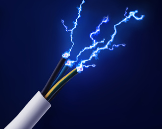 Image of Sparking cables on dark blue background, closeup. Electrician's supply