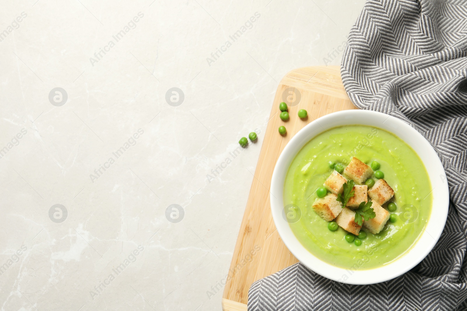 Photo of Flat lay composition with fresh vegetable detox soup made of green peas in dish and space for text on table