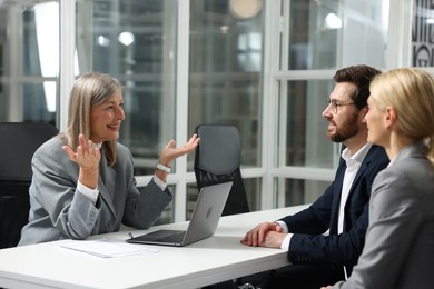 Photo of Lawyer working with clients at table in office