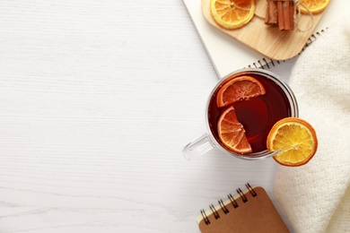 Photo of Flat lay composition with cup of tea on white wooden table, space for text. Cozy winter