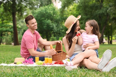 Photo of Happy family having picnic in park on summer day