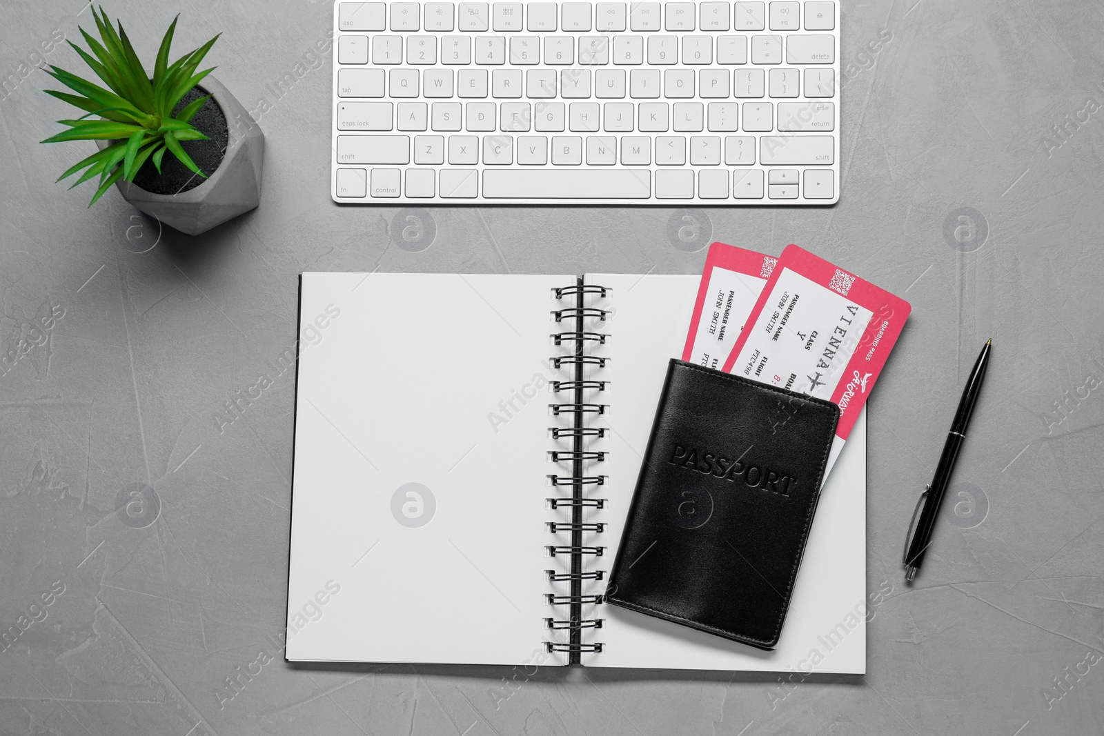 Photo of Flat lay composition with tickets, passport and notebook on light grey table, space for text. Business trip