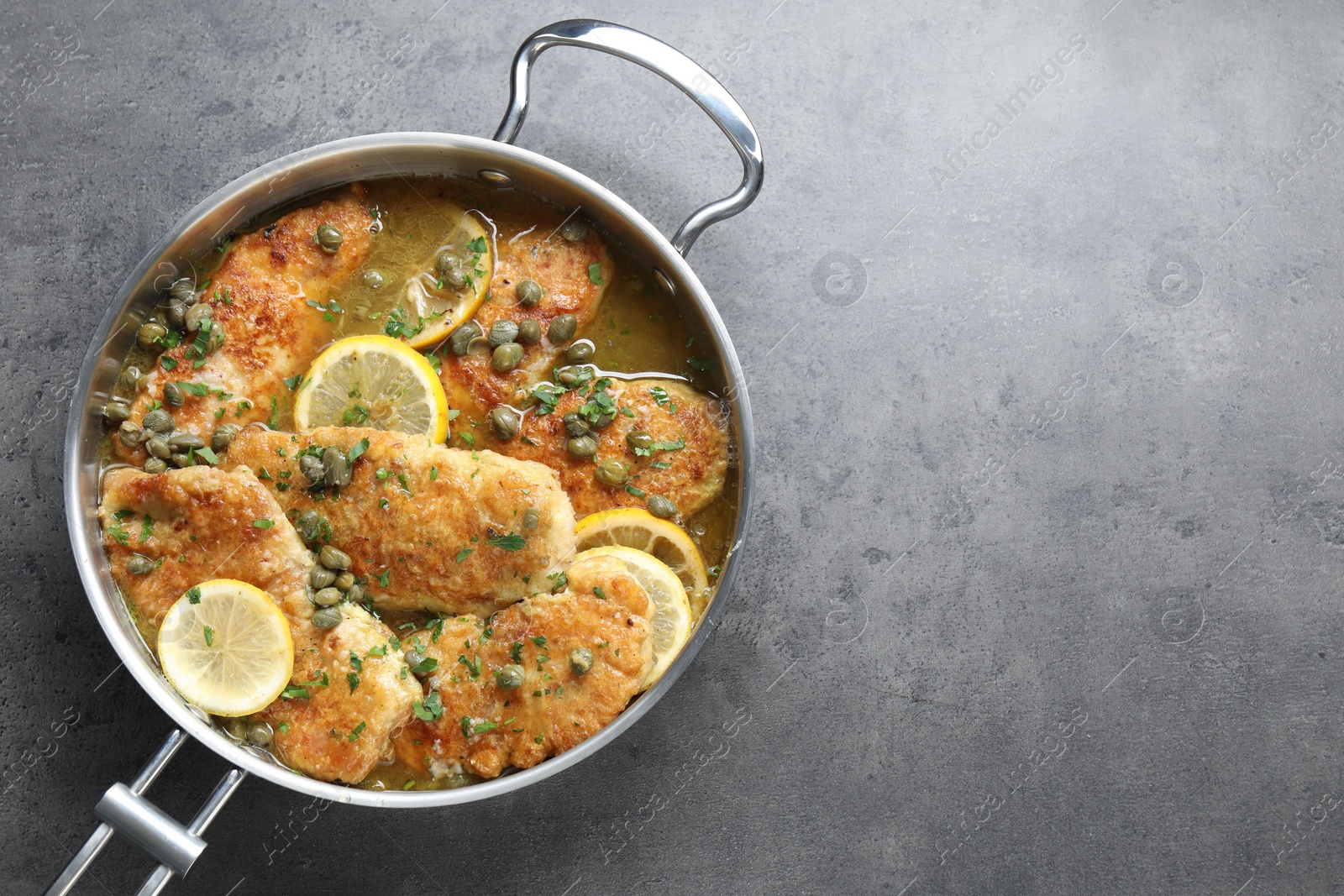 Photo of Delicious chicken piccata on grey table, top view. Space for text