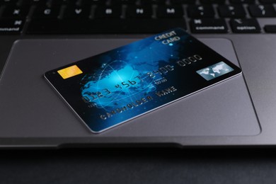 Photo of Laptop with credit card on grey table, closeup