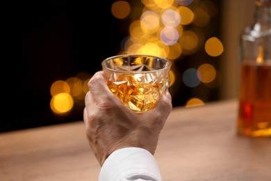 Photo of Senior man with glass of whiskey at bar counter, closeup