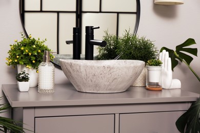 Photo of Stylish sink and beautiful green houseplants in bathroom. Interior design