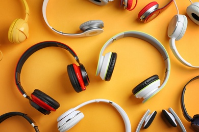 Photo of Many different headphones on color background, top view