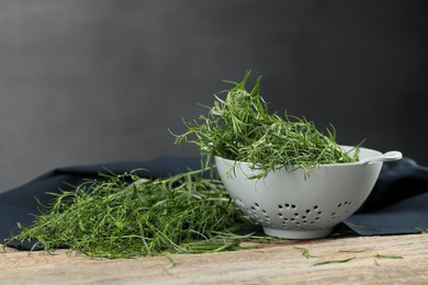 Photo of Fresh tarragon sprigs on wooden table. Space for text