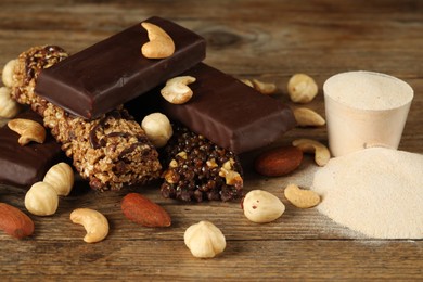 Photo of Different tasty bars, nuts and protein powder on wooden table