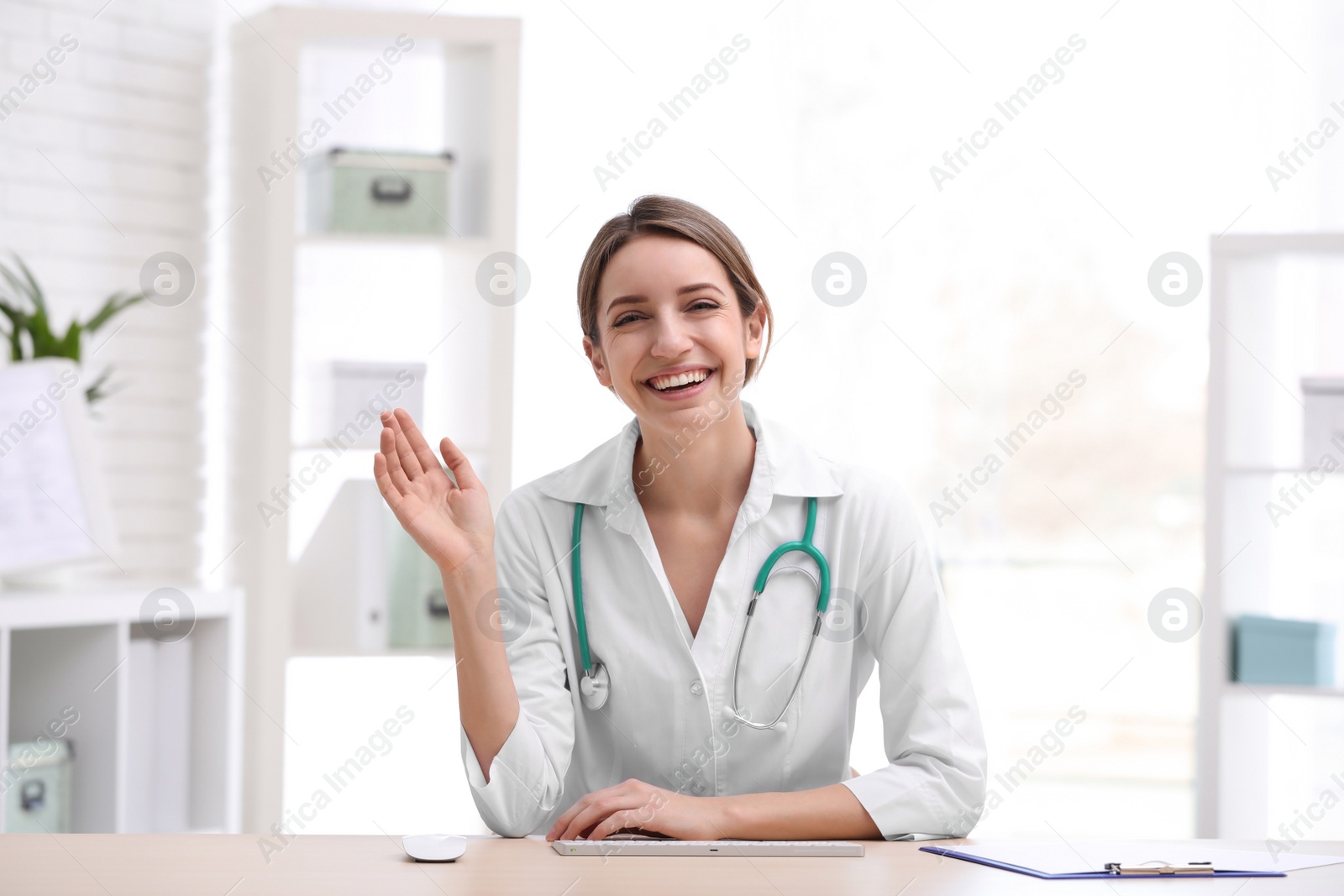 Photo of Female doctor using video chat at workplace, view from camera perspective