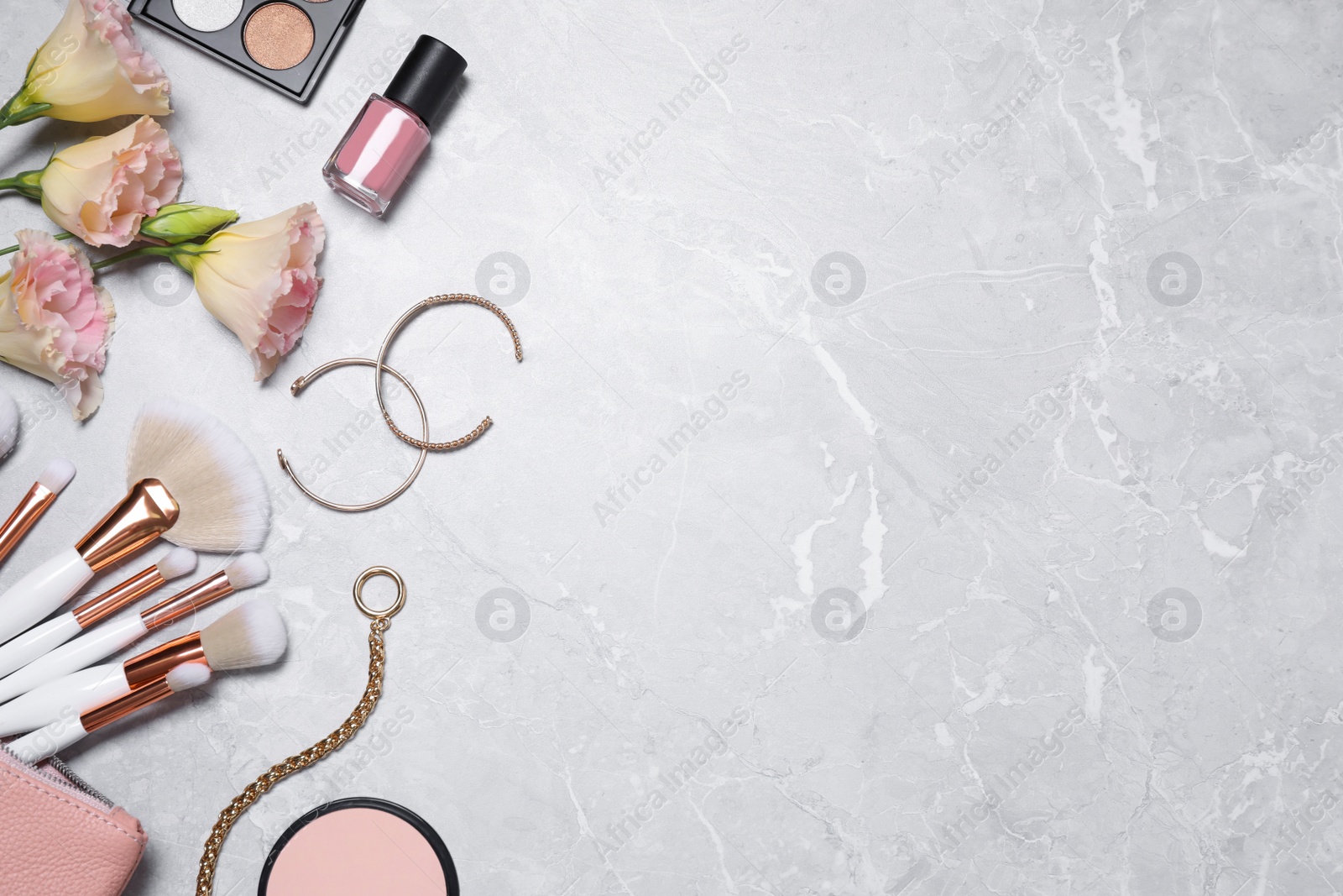 Photo of Flat lay composition with makeup products and accessories on light grey marble background. Space for text