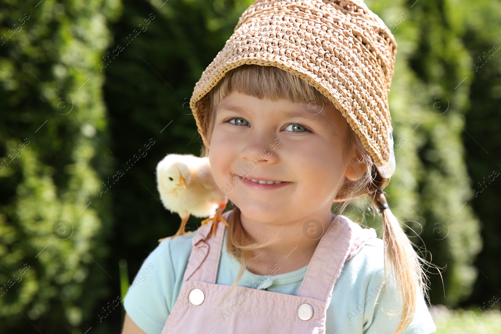 Photo of Cute little girl with chick outdoors. Baby animal