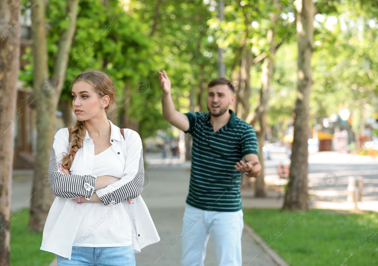 Photo of Young couple arguing on street. Problems in relationship