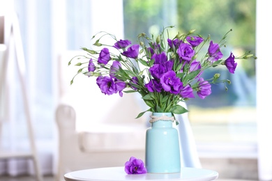 Photo of Beautiful bouquet of purple eustoma flowers in vase on table