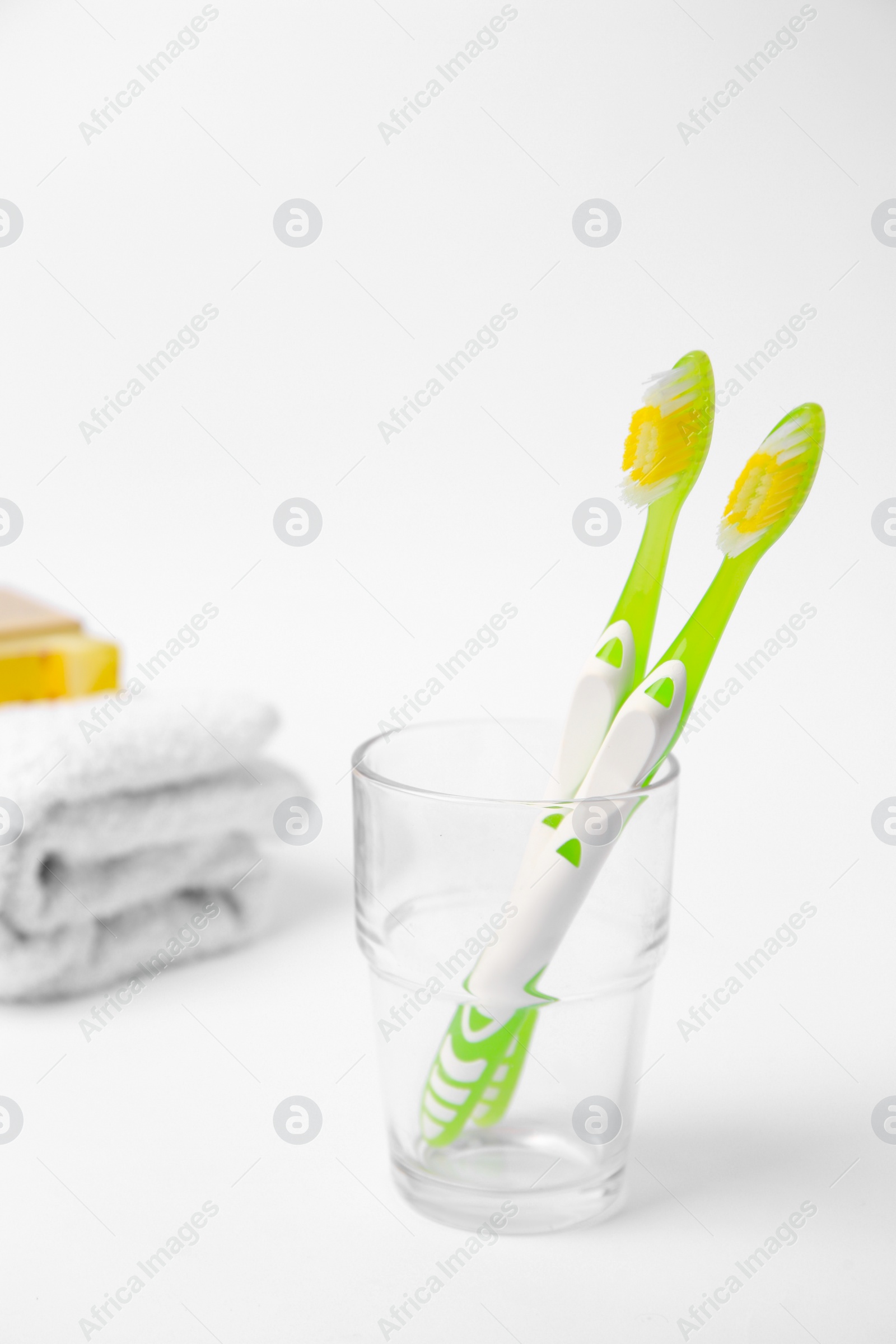 Photo of Light green toothbrush in glass holder on white background