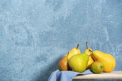 Fresh ripe pears on table against color background. Space for text