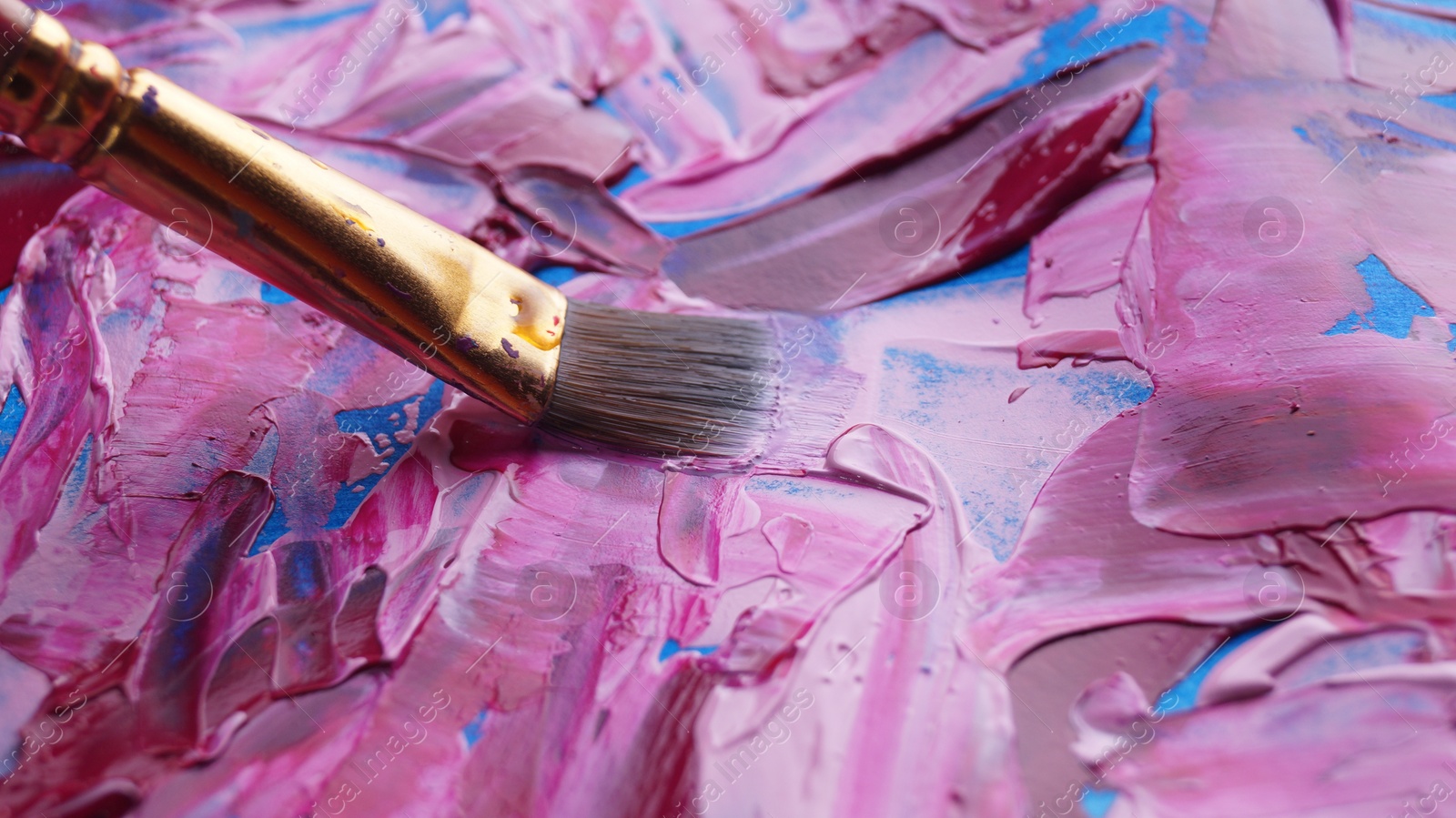 Photo of Brush on artist's palette with mixed paints, closeup