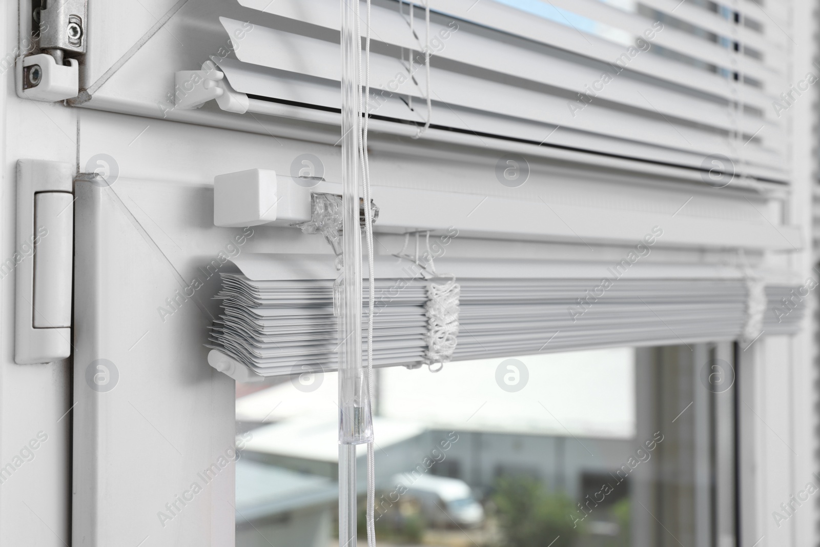 Photo of Window with horizontal blinds and control system indoors, closeup