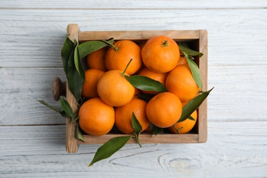 Photo of Crate with fresh ripe tangerines on wooden background, top view