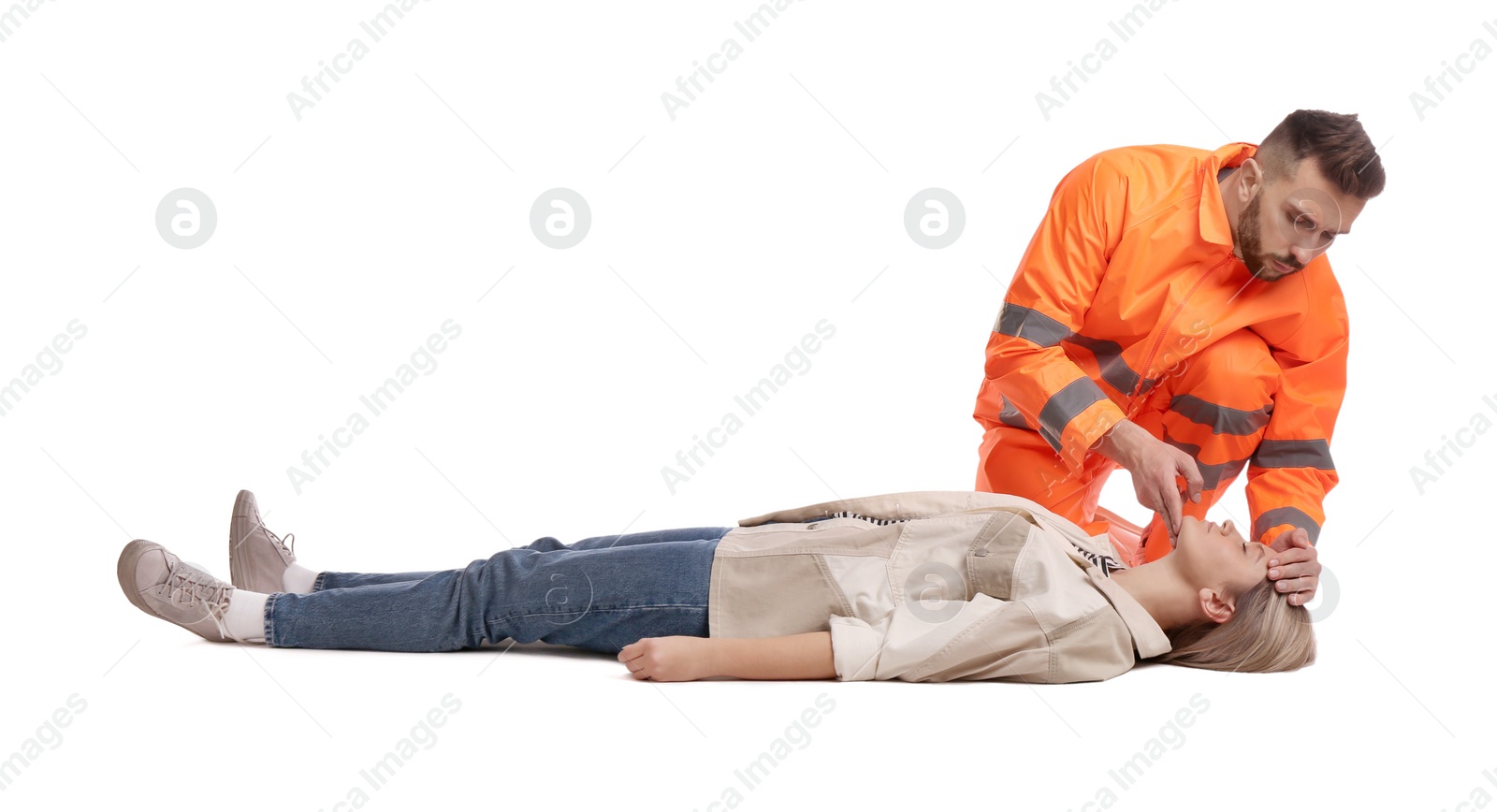 Photo of Paramedic in uniform performing first aid on unconscious woman against white background