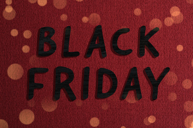 Phrase Black Friday and beautiful red fabric on background 