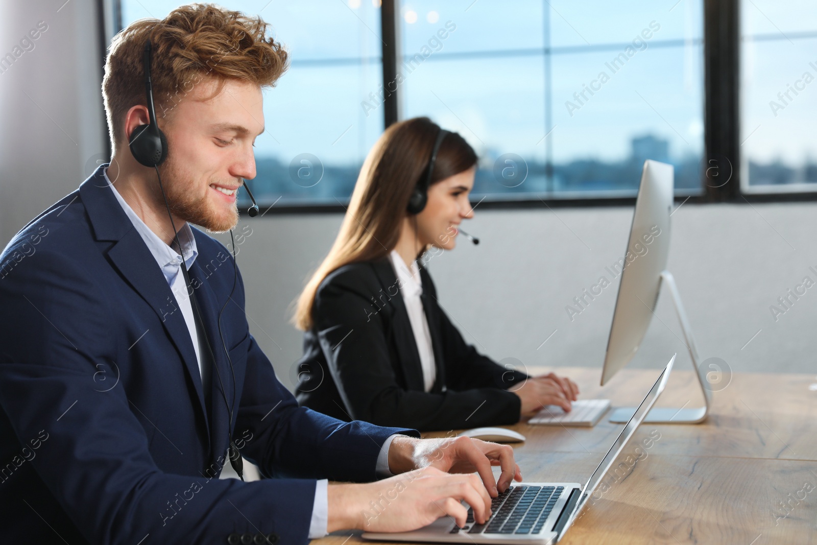 Photo of Technical support operator with colleague in modern office