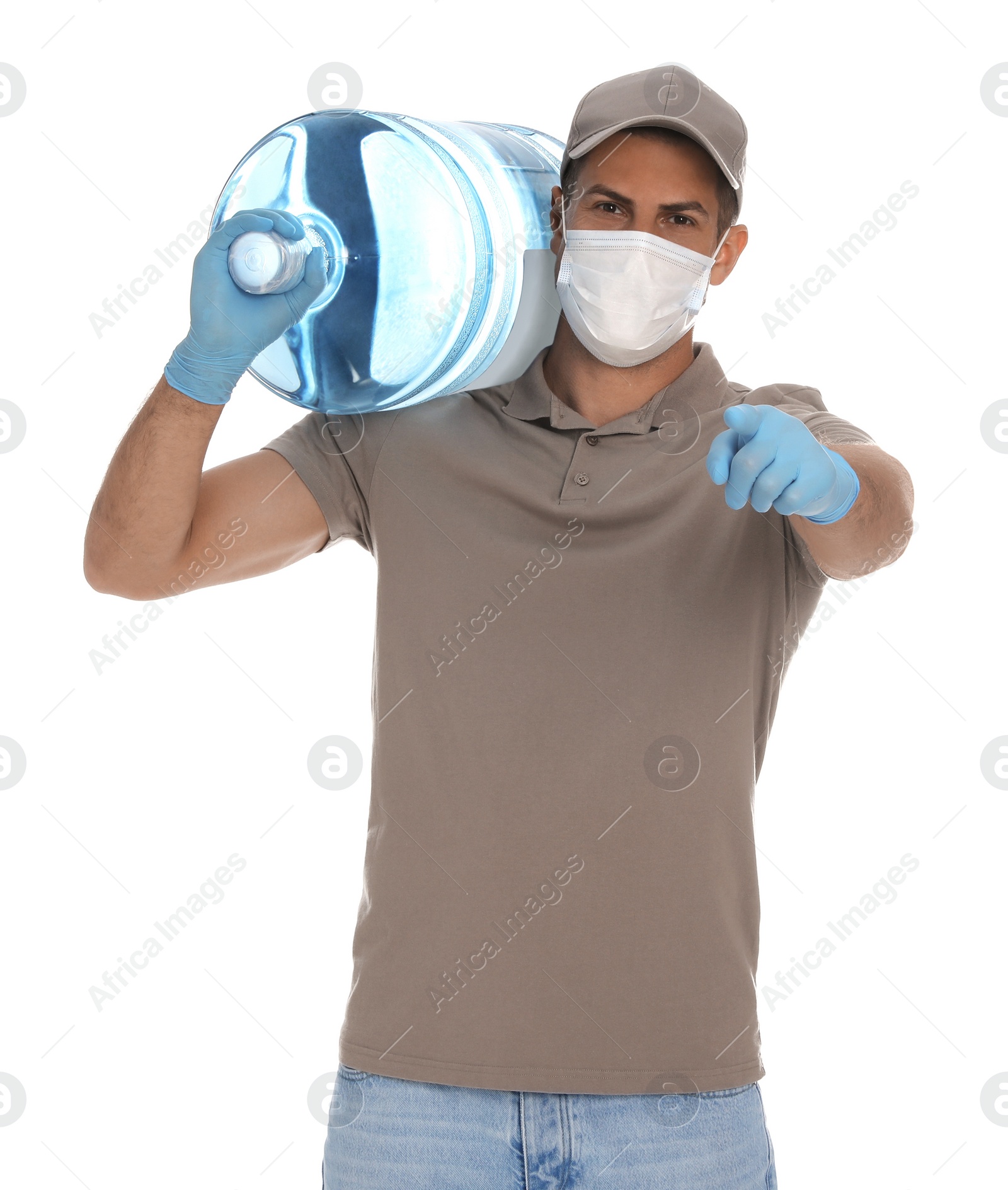 Photo of Courier in medical mask holding bottle for water cooler on white background. Delivery during coronavirus quarantine