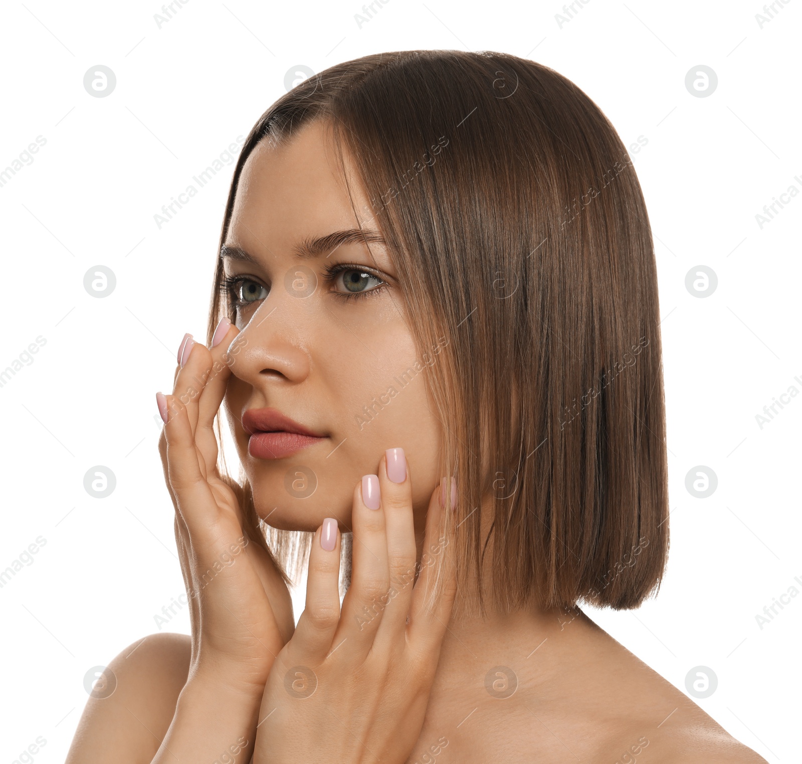 Photo of Young woman applying cream under eyes on white background