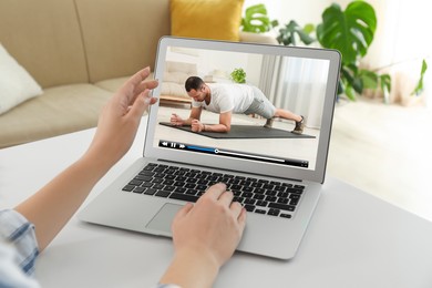 Image of Woman watching morning exercise video on laptop at home, closeup