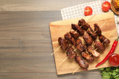 Photo of Delicious shish kebabs served on wooden table, flat lay. Space for text