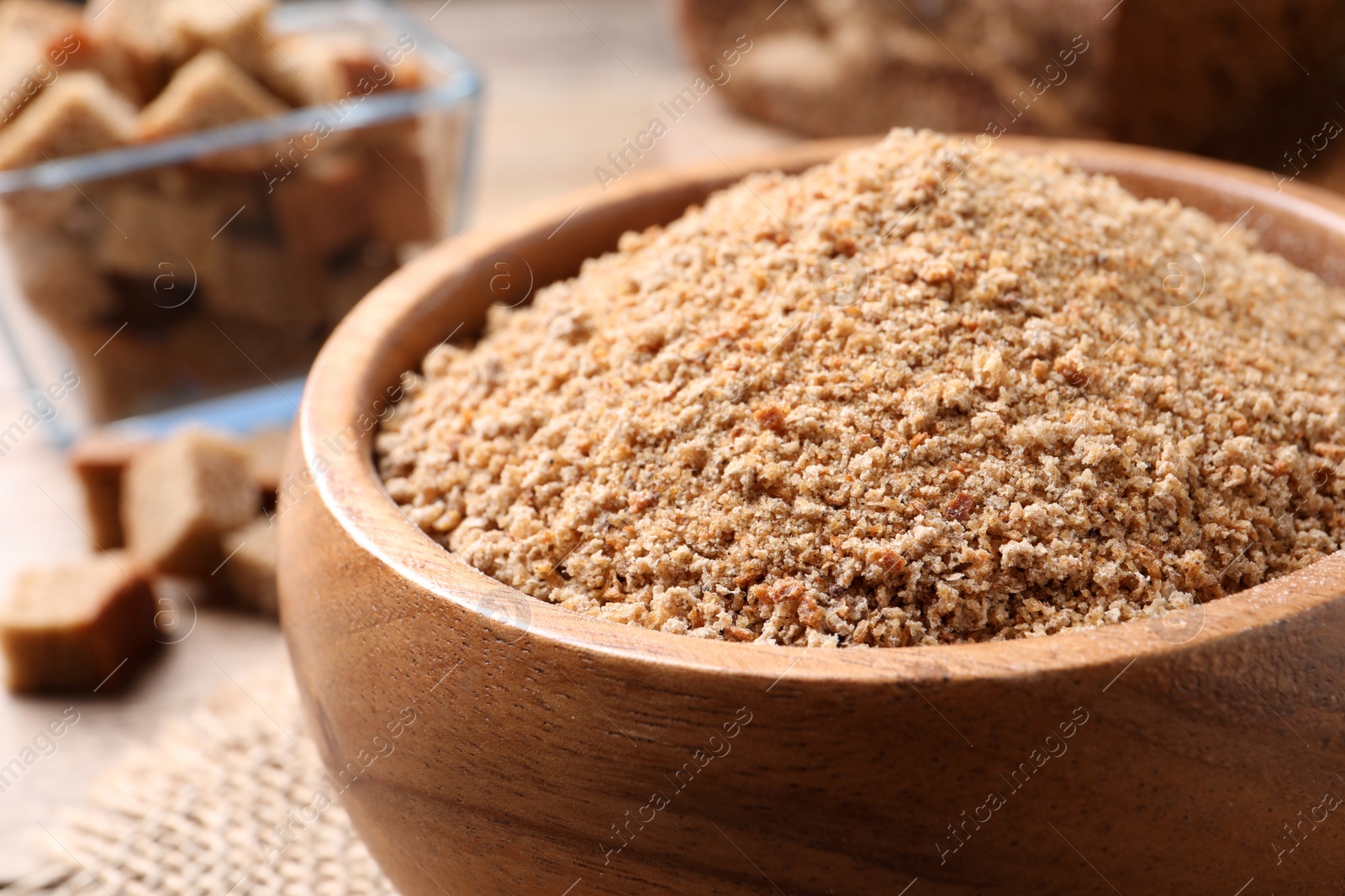 Photo of Fresh breadcrumbs in bowl on table, closeup