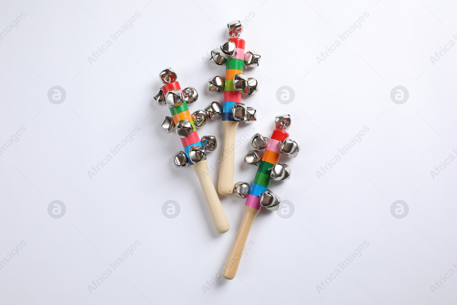 Photo of Wooden shakers with bells on white background, top view. Montessori musical toy