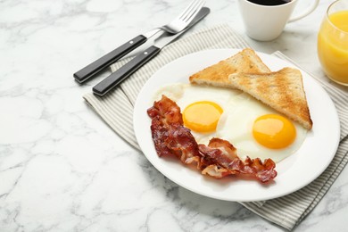 Delicious breakfast with sunny side up eggs served on white marble table